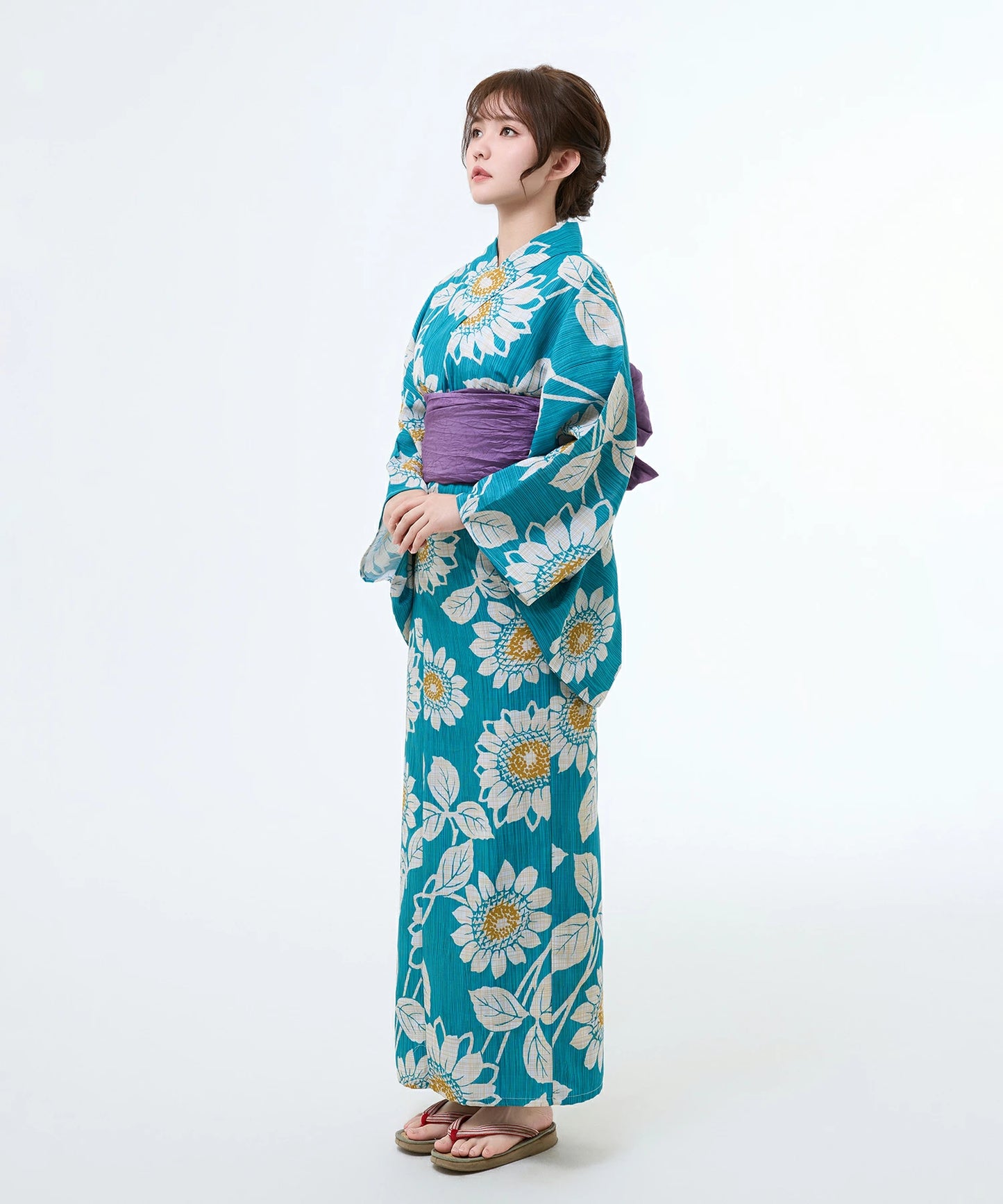 Woman wearing a blue floral kimono with a white background