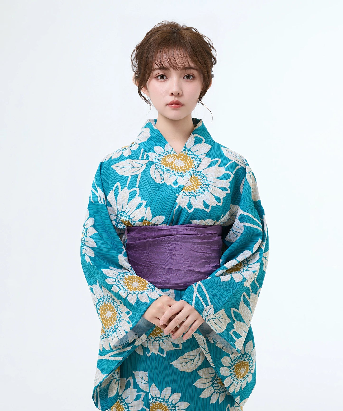 Woman wearing a blue floral kimono with a white background