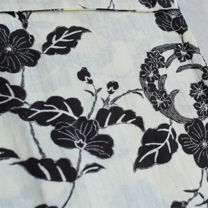Close-up of fabric with black floral pattern on a white background